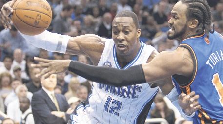 Dwight Howard (izq.), de Orlando, conduce el balón ante la marca de Ronny Turiaf, de los Knicks de Nueva York. AP  /