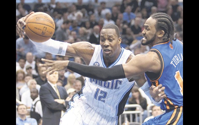 Dwight Howard (izq.), de Orlando, conduce el balón ante la marca de Ronny Turiaf, de los Knicks de Nueva York. AP  /