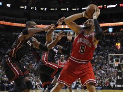 Carlos Boozer (5) dispara ante la marca de Chris Bosh (izq.) y de Dwyane Wade. REUTERS  /