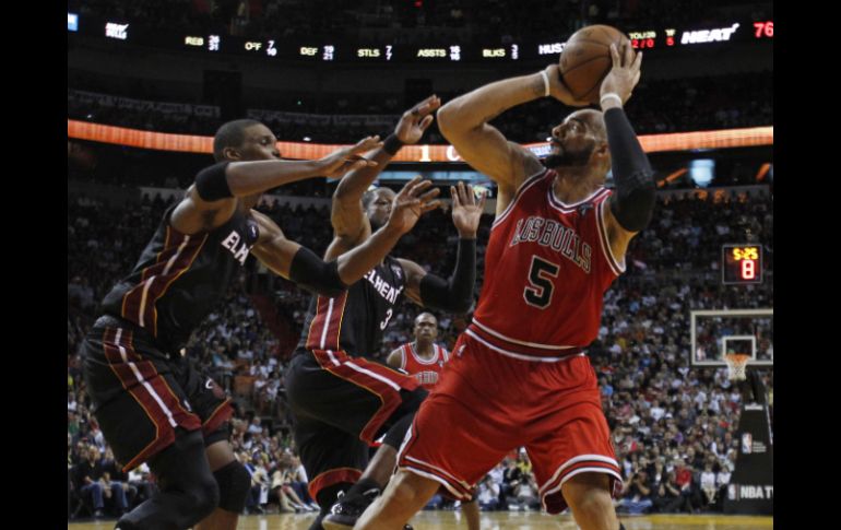 Carlos Boozer (5) dispara ante la marca de Chris Bosh (izq.) y de Dwyane Wade. REUTERS  /