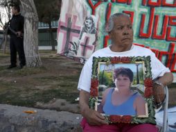 Sara Reyes sostiene una foto de su hija Magdalena durante una protesta en Ciudad Juárez. ARCHIVO  /