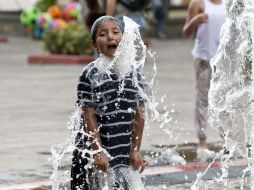 Niño juega en las fuentes de la ciudad para combatir el calor. E. PACHECO  /