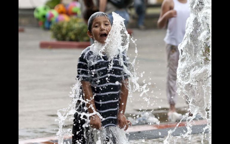 Niño juega en las fuentes de la ciudad para combatir el calor. E. PACHECO  /