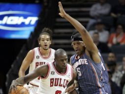 Luol Deng (izq.) esquiva a Dominic McGuire, de los Bobcats. AP  /