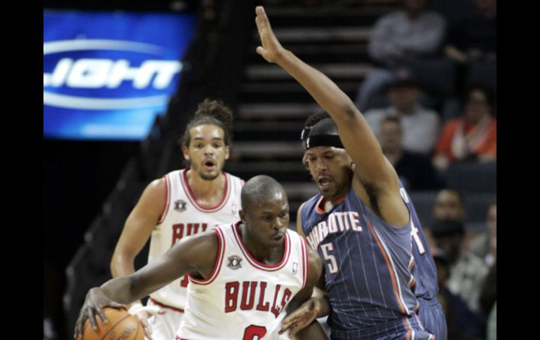 Luol Deng (izq.) esquiva a Dominic McGuire, de los Bobcats. AP  /