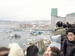 Gente de la ciudad japonesa de Kesennuma mira las calles inundadas tras el tsunami. REUTERS  /