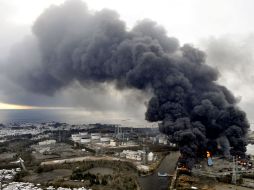 Humo se eleva de edificios en una zona industrial de Sendai, ciudad afectada por el sismo. AP  /