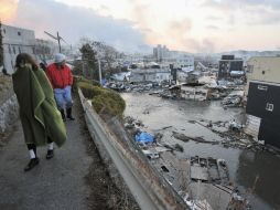 Residentes de Kesen Numa caminan y observan el desastre ocasionado por el tsunami en el Estado de Miyagi, ubicado al norte de Japón. AP  /