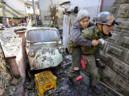 Un día después del sismo y posterior tsunami, soldados japoneses rescatan a la población en zonas dañadas. AP  /