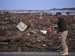 Un anciano observa una zona devastada por el maremoto mientras busca a familiares en Soma. EFE  /