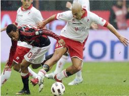 El delantero brasileño del AC Milan, Robinho (c), se disputa el balón con el centrocampista del Bari, Sergio Bernardo Almiron. EFE  /