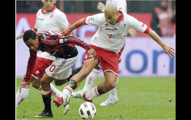 El delantero brasileño del AC Milan, Robinho (c), se disputa el balón con el centrocampista del Bari, Sergio Bernardo Almiron. EFE  /