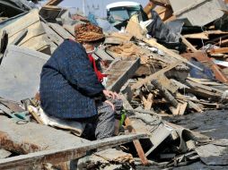 Una anciana sentada entre los escombros de una localidad de Miyagi, donde reportan mil 167 personas desaparecidas. EFE  /