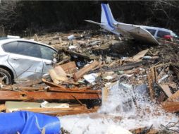 Una avioneta junto a un vehículo entre escombros en el puerto de Sendai, Japón. EFE  /