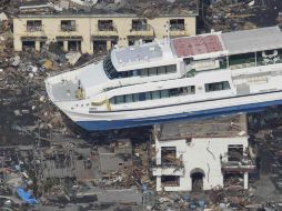 Un barco permanece hoy sobre un edificio en Otsuchi, luego del terremoto y tsunami que azotaron a Japón. AP  /