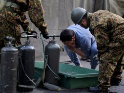 Un hombre evacuado de los alrededores de la planta de Fukushima se lava en un área instalada por las fuerzas armadas. REUTERS  /