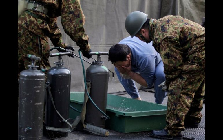 Un hombre evacuado de los alrededores de la planta de Fukushima se lava en un área instalada por las fuerzas armadas. REUTERS  /