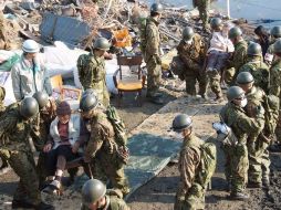 Miembros de las fuerzas de defensa de Japón evacúan a damnificados. EFE  /