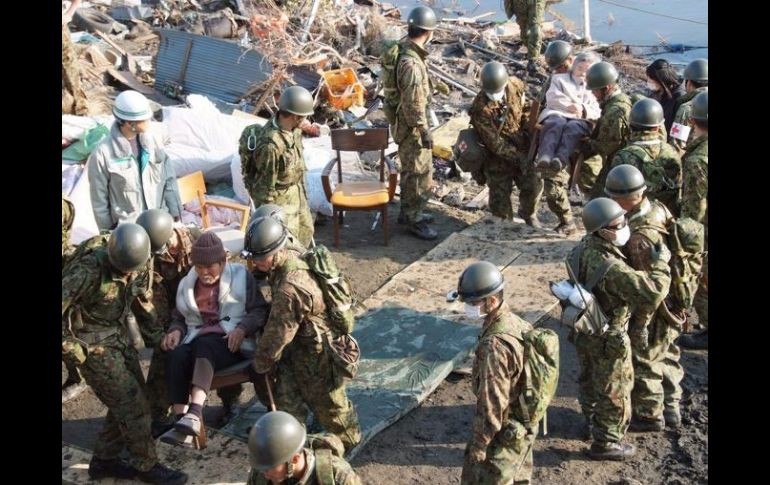 Miembros de las fuerzas de defensa de Japón evacúan a damnificados. EFE  /