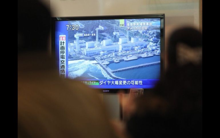 Varias personas ven las noticias informan sobre la situación en la central nuclear de Fukushima. EFE  /