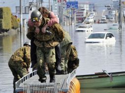 Un militar japonés socorre a una damnificada en la provincia de Miyagi. AP  /