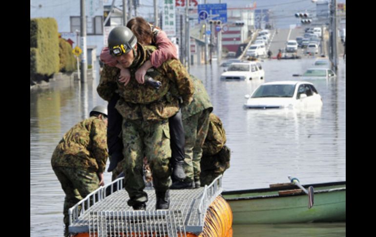 Un militar japonés socorre a una damnificada en la provincia de Miyagi. AP  /