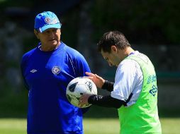 Enrique Meza platica con el volante argentino Christian Giménez. MEXSPORT  /