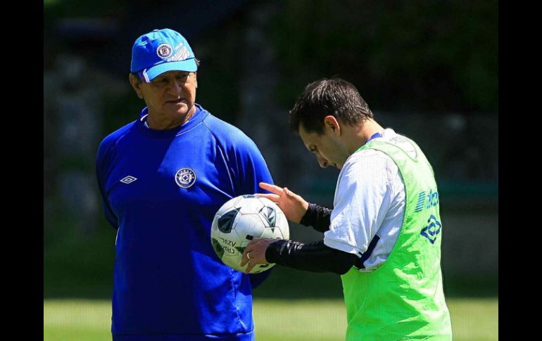 Enrique Meza platica con el volante argentino Christian Giménez. MEXSPORT  /