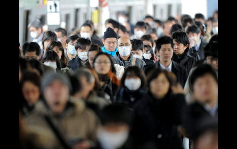 Habitantes de Tokio portan cubrebocas. En la ciudad se detectaron niveles de radiación mayores a lo usual. EFE  /