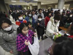 Imágenes de un centro de refugio para evacuados de Fukushima, el índice de radiación de las personas es medido a su ingreso. AP  /