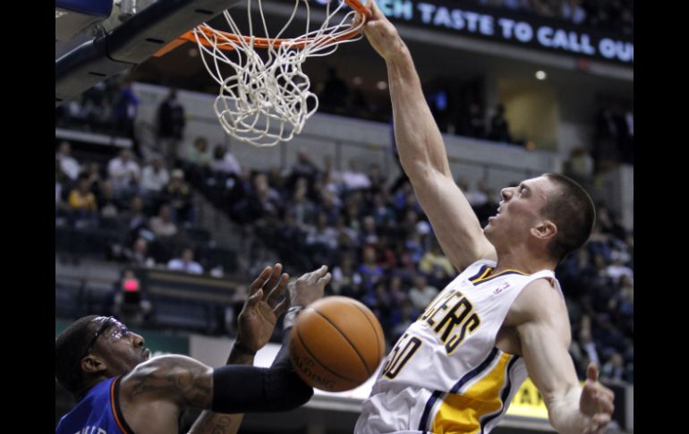 Tyler Hansbrough (blanco) sume el balón en la canasta de los Knicks de Nueva York, ante la impotencia de Amare Stoudemire (izq.). AP  /