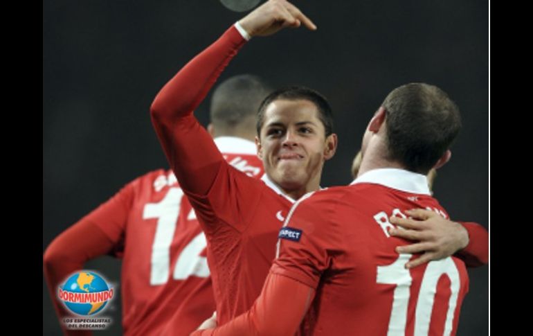 Rooney celebra con el 'Chicharito', el primer gol del mexicano, el cual lo concretó tras un pase de Rooney. EFE  /