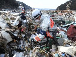 Rescatistas buscan hoy debajo de los escombros en la prefectura de Miyagi, una de las zonas más afectadas por la catástrofe. AFP  /