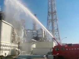 Durante varias horas, camiones de bomberos arrojaron agua al reactor para lograr bajar la temperatura. AFP  /