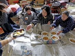 Evacuados reciben raciones de comida en un refugio improvisado en la ciudad costera de Rikuzentakata. EFE  /