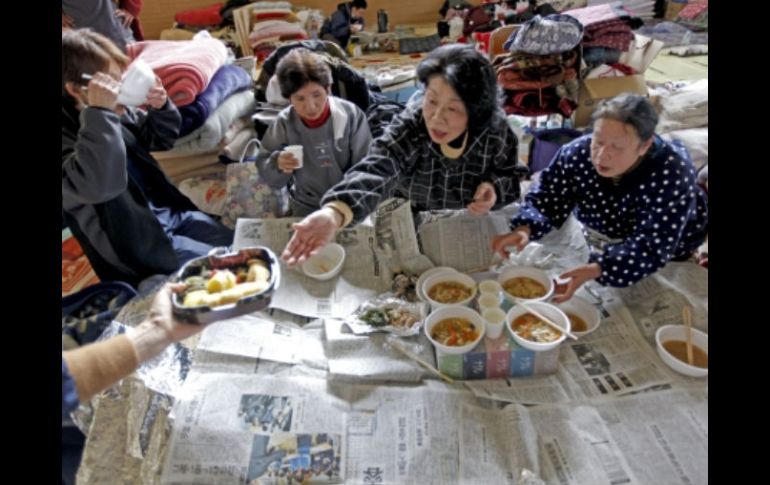 Evacuados reciben raciones de comida en un refugio improvisado en la ciudad costera de Rikuzentakata. EFE  /