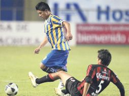 Juan Carlos Medina evade la barrida del defensor rojinegro, Ricardo Jiménez. MEXSPORT  /