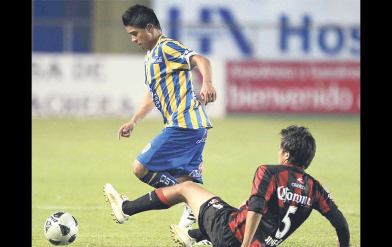 Juan Carlos Medina evade la barrida del defensor rojinegro, Ricardo Jiménez. MEXSPORT  /