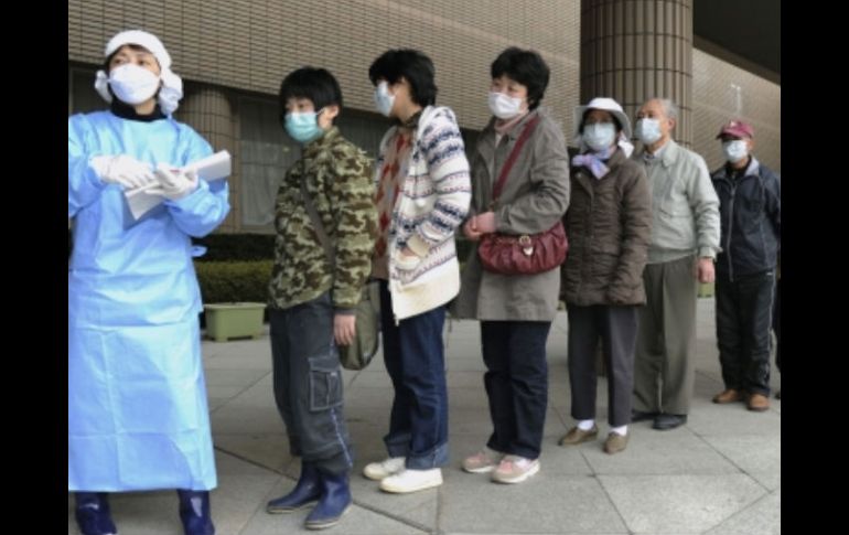 Las personas están en línea para recibir las pruebas de exposición a la radiación en  un estadio deportivo en Fukushima. AP  /