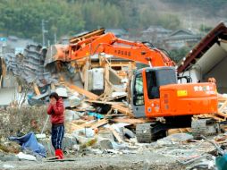 Una mujer llora al ver su nueva casa en ruinas tras el paso del tsunami hace nueve días por la prefectura de Iwate, en Japón. EFE  /