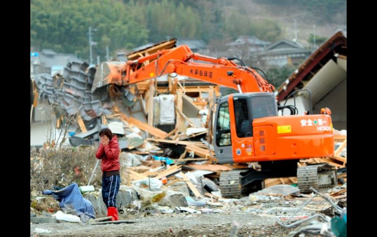 Una mujer llora al ver su nueva casa en ruinas tras el paso del tsunami hace nueve días por la prefectura de Iwate, en Japón. EFE  /