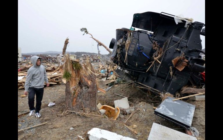 Un hombre mira hoy una locomotora, ubicada a 30 metros de la vía de tren, en la prefectura de Miyagi. REUTERS  /