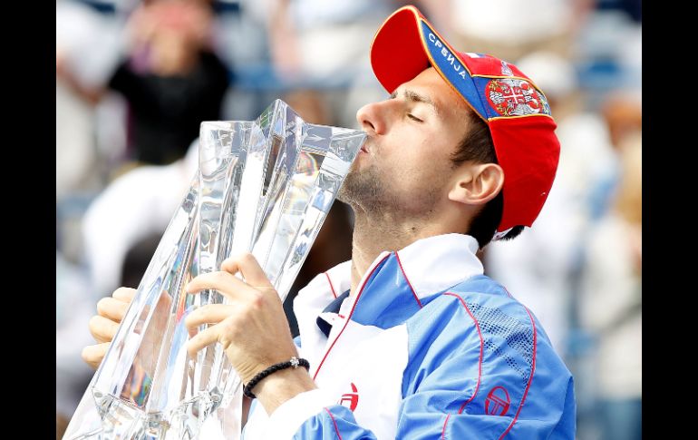 Novak Djokovic, quien besa el trofeo que ganó ayer en Indian Wells, California, conquistó su tercer título de 2011. AFP  /