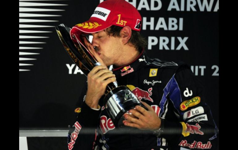 El piloto alemán Sebastian Vettel, besa el trofeo ganado en el Grand Prix 2010 celebrado en Abu Dabi.  AFP  /