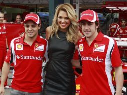 Los pilotos de Ferrari, Felipe Massa y Fernando Alonso, posan con la embajadora de Grand Prix en Australia. REUTERS  /