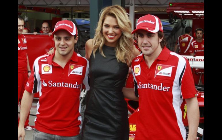 Los pilotos de Ferrari, Felipe Massa y Fernando Alonso, posan con la embajadora de Grand Prix en Australia. REUTERS  /