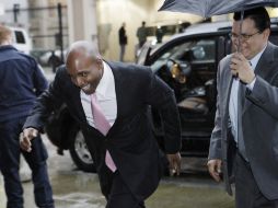 Barry Bonds intenta huir entre risas de la lluvia que cayó en San Francisco. AP  /