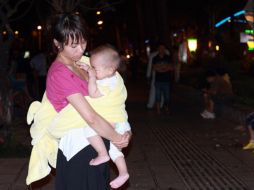 Una mujer china sostiene a su bebé afuera de su hogar, luego de las réplicas del terremoto que sacudió Birmania. EFE  /