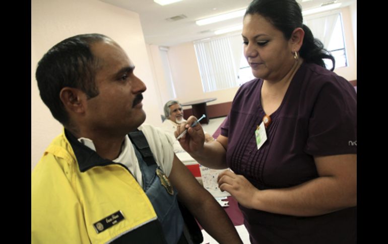 Un agente de tránsito es vacunado contra la influenza. EFE  /