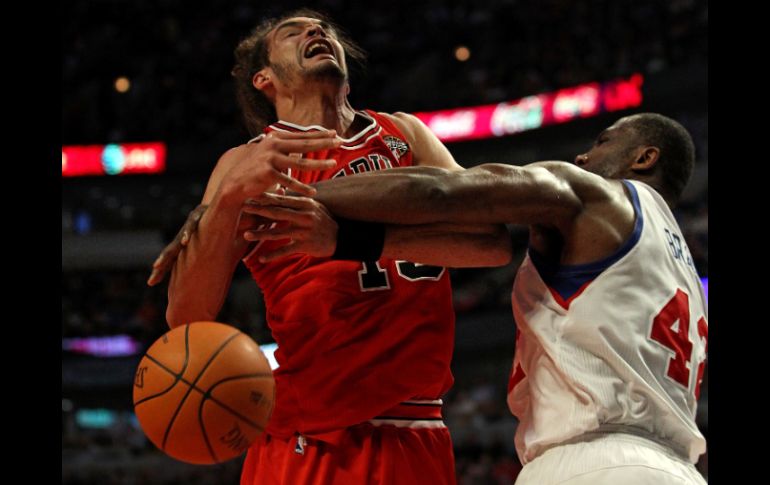 Joakim Noah (13) de los Bulls de Chicago es desplazado del balón por Elton Brand, de los 76ers de Filadelfia. AFP  /